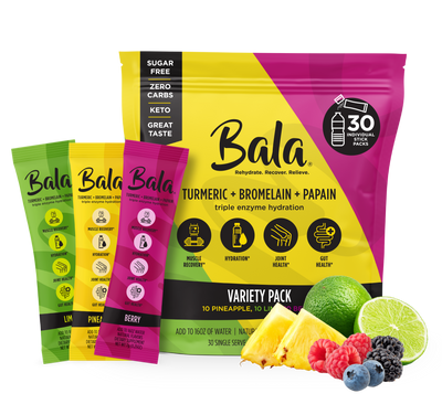 A variety pack of Bala Enzyme Bala Total Body Wellness Drink Mix, featuring individual packets in lime, lemon, and berry flavors with images of pineapple, lime, blueberries, raspberries, and blackberries in the foreground. Enhanced with electrolytes and ENZYMX RECOVERY ACCELERATOR for optimal refreshment.